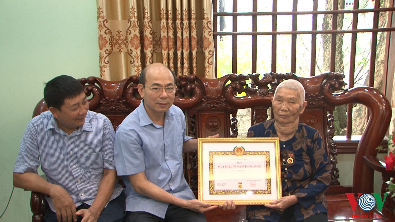 Đồng chí Trần Xuân Thành - Phó BT TT HU gắn Huy Hiệu Đảng cho Đảng viên Nguyễn Thị Dẻn. Ảnh: Khắc Hùng