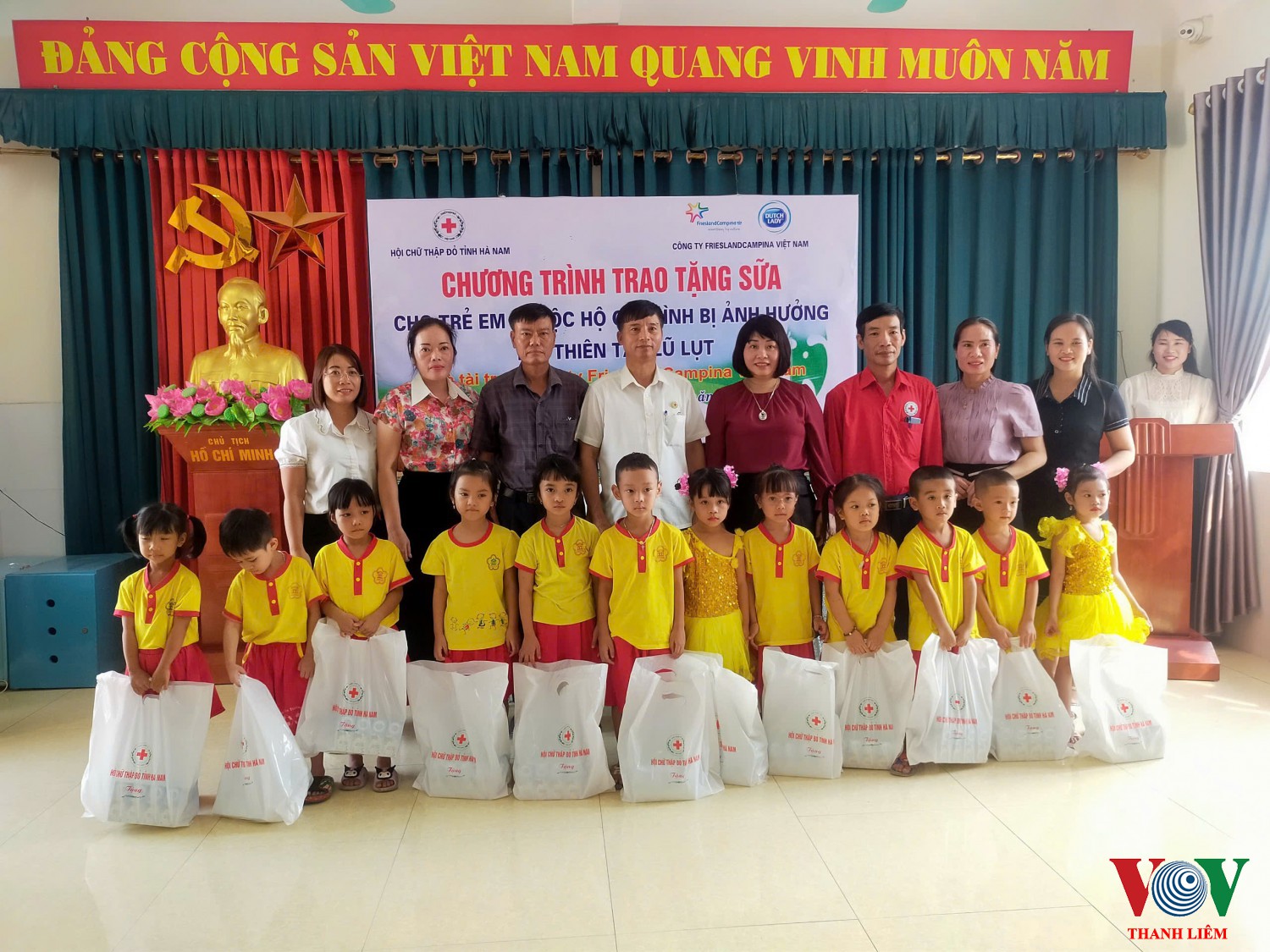 Các đại biểu trao quà cho các cháu vùng ngập lụt